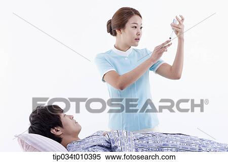 a nurse getting ready for injection next to a patient View Large Photo Image Stock Photography - a nurse getting ready for injection next to a patient. Fotosearch
