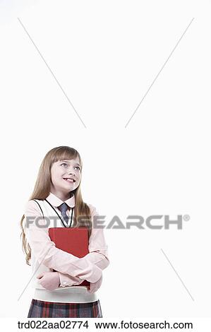 a student in uniform holding a book on white background View Large Photo Image Picture - a student in uniform holding a book on white background. Fotosearch