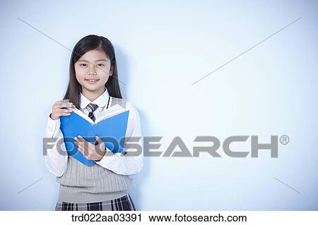 a student in uniform holding a book View Large Photo Image Stock Image - a student in uniform holding a book. Fotosearch