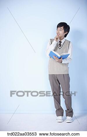 Stock Image - a student in uniform holding a book. Fotosearch