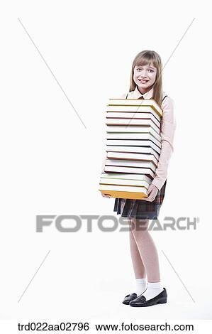 a student in uniform holding a pile of books View Large Photo Image Stock Photograph - a student in uniform holding a pile of books. Fotosearch
