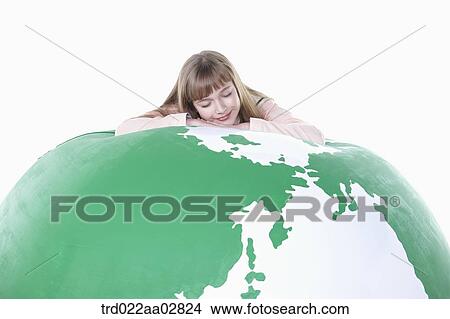 a student in uniform leaning on top of a globe View Large Photo Image Picture - a student in uniform leaning on top of a globe. Fotosearch