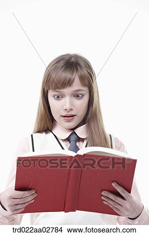 Picture - a student in uniform reading a book on white background. Fotosearch