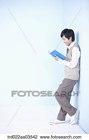 a student in uniform reading a book while leaning on the wall View Large Photo Image Stock Image - a student in uniform reading a book while leaning on the wall. Fotosearch