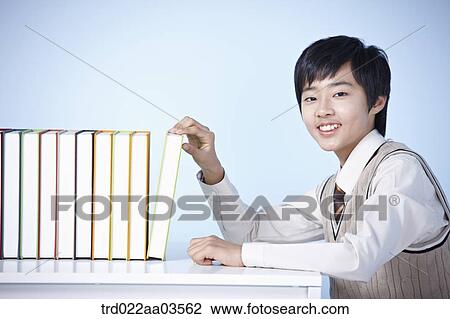 a student in uniform sitting at table taking a book View Large Photo Image Stock Image - a student in uniform sitting at table taking a book. Fotosearch