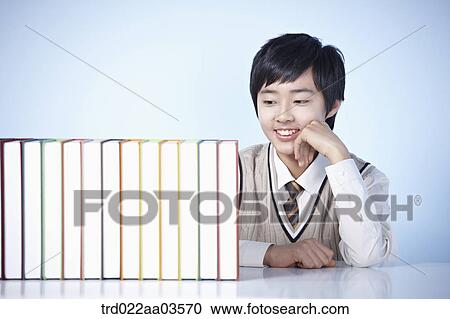 a student in uniform sitting at table with books View Large Photo Image Stock Image - a student in uniform sitting at table with books. Fotosearch