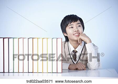 a student in uniform sitting at table with books View Large Photo Image Stock Image - a student in uniform sitting at table with books. Fotosearch