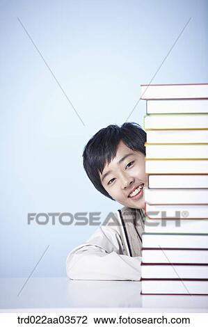 a student in uniform sitting at table with a pile of books View Large Photo Image Stock Image - a student in uniform sitting at table with a pile of books. Fotosearch