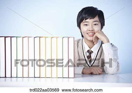 a student in uniform sitting at table with books View Large Photo Image Stock Photo - a student in uniform sitting at table with books. Fotosearch