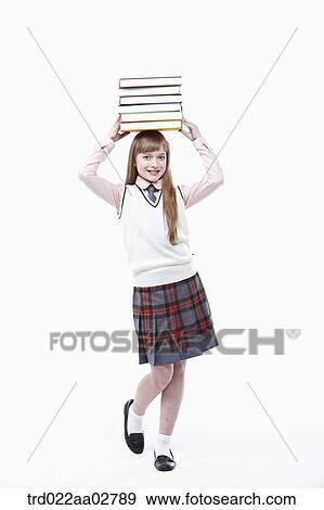 a student in uniform with a pile of books on head View Large Photo Image Stock Photo - a student in uniform with a pile of books on head. Fotosearch