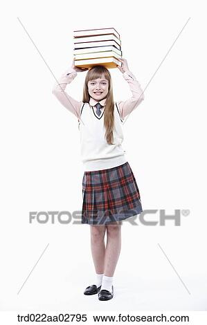 a student in uniform with a pile of books on head View Large Photo Image Stock Photography - a student in uniform with a pile of books on head. Fotosearch