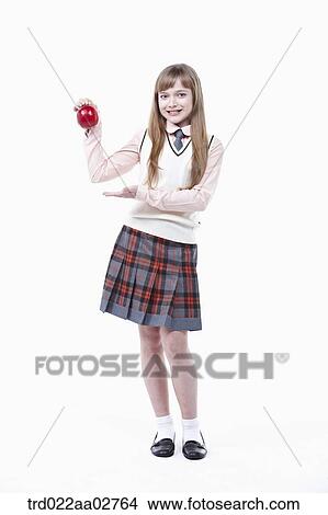a student in uniform with an apple on white background View Large Photo Image Picture - a student in uniform with an apple on white background. Fotosearch