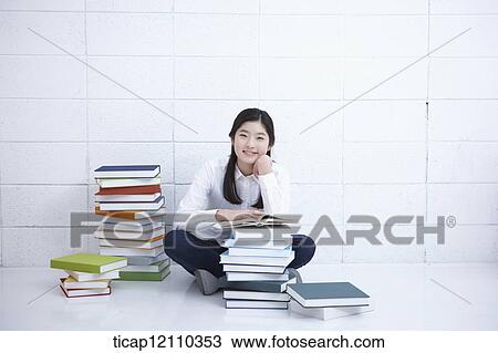 a student reading a book while sitting on the floor View Large Photo Image Stock Image - a student reading a book while sitting on the floor. Fotosearch