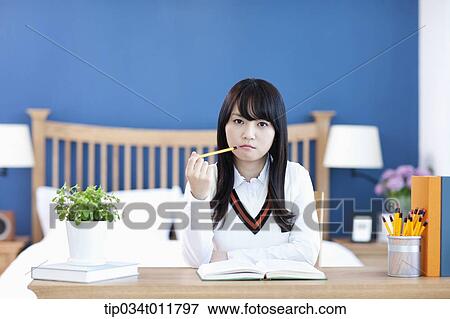 Stock Photo - a student sitting at a desk. Fotosearch