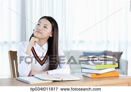 a student sitting at desk smiling View Large Photo Image Stock Photo - a student sitting at desk smiling. Fotosearch