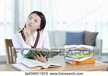 a student sitting at desk studying View Large Photo Image Stock Photo - a student sitting at desk studying. Fotosearch