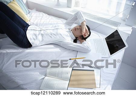 a student sleeping on bed while studying View Large Photo Image Stock Photo - a student sleeping on bed while studying. Fotosearch