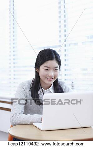 Stock Image - a student using a laptop. Fotosearch