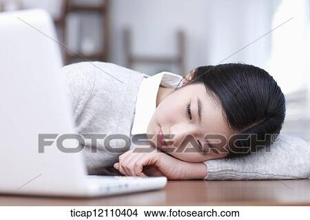 Picture - a student using laptop in study room. Fotosearch