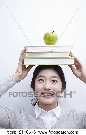 a student with a pile of books on the head View Large Photo Image Stock Photograph - a student with a pile of books on the head. Fotosearch