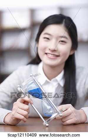 Stock Photo - a student with sand hour glass. Fotosearch