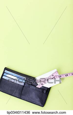 Stock Photograph - a wallet with a measurement band around a card. Fotosearch