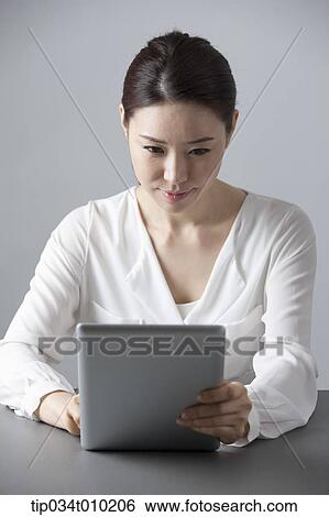 a woman at desk using a tablet PC View Large Photo Image Stock Photograph - a woman at desk using a tablet PC . Fotosearch
