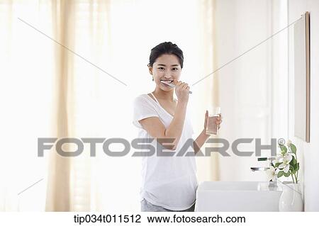 Stock Image - a woman brushing teeth. Fotosearch