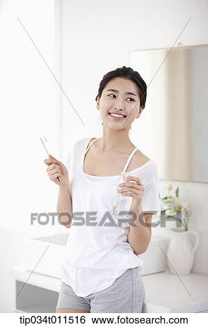 Stock Photograph - a woman brushing teeth. Fotosearch