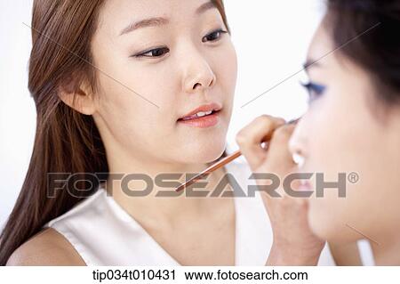Stock Image - a woman getting professional make up. Fotosearch