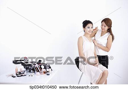 Stock Image - a woman getting professional make up. Fotosearch