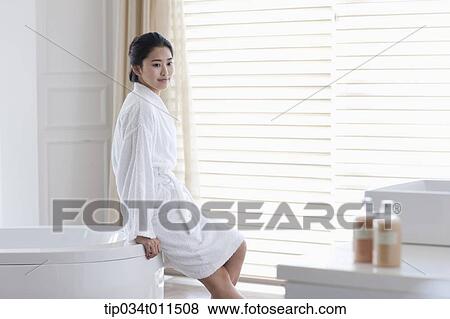 Stock Photo - a woman in bathrobe leaning on a Jacuzzi. Fotosearch