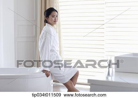 Stock Photo - a woman in bathrobe leaning on a Jacuzzi. Fotosearch