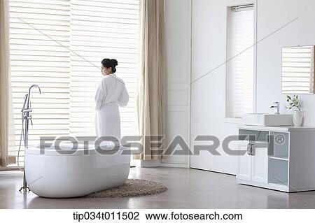 a woman in bathrobe standing in a bath room View Large Photo Image Stock Image - a woman in bathrobe standing in a bath room. Fotosearch