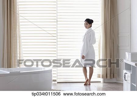 a woman in bathrobe standing in a bath room View Large Photo Image Stock Photograph - a woman in bathrobe standing in a bath room. Fotosearch