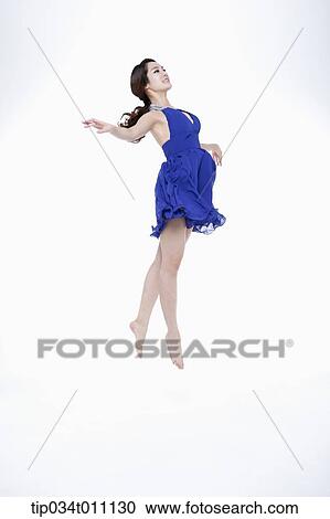 Stock Image - a woman in blue fancy dress posing like a ballerina. Fotosearch
