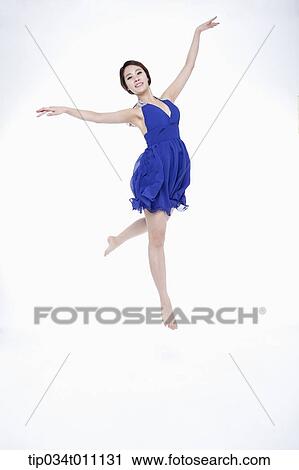 Stock Image - a woman in blue fancy dress posing like a ballerina. Fotosearch