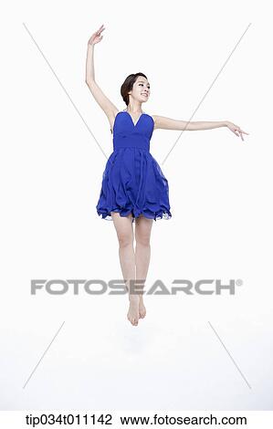 Stock Image - a woman in blue fancy dress posing like a ballerina. Fotosearch