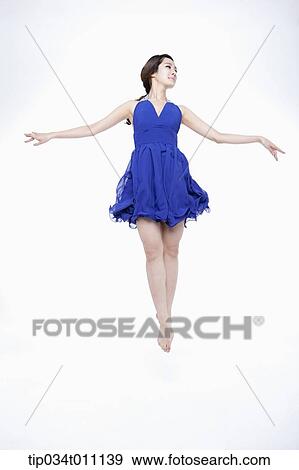 Stock Photo - a woman in blue fancy dress posing like a ballerina. Fotosearch