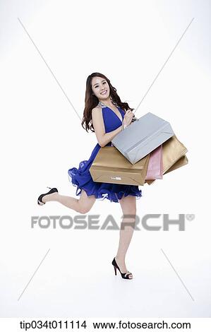 Picture - a woman in blue fancy dress running with shopping bags. Fotosearch