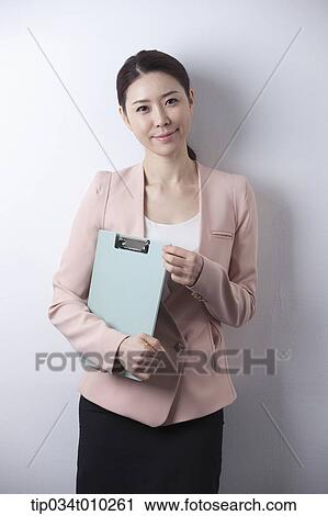 a woman in business suit holding a folder View Large Photo Image Stock Image - a woman in business suit holding a folder. Fotosearch