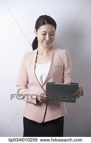 a woman in business suit holding a folder View Large Photo Image Stock Photo - a woman in business suit holding a folder. Fotosearch