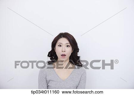 a woman in grey plain shirt looking surprised View Large Photo Image Stock Image - a woman in grey plain shirt looking surprised. Fotosearch
