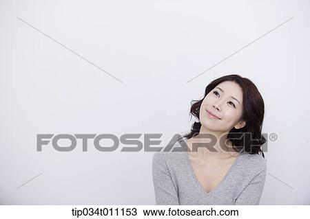 Stock Image - a woman in grey plain shirt smiling. Fotosearch