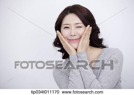 Stock Image - a woman in grey plain shirt smiling. Fotosearch