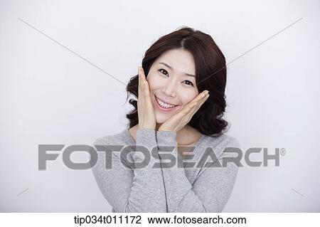 Stock Image - a woman in grey plain shirt smiling. Fotosearch