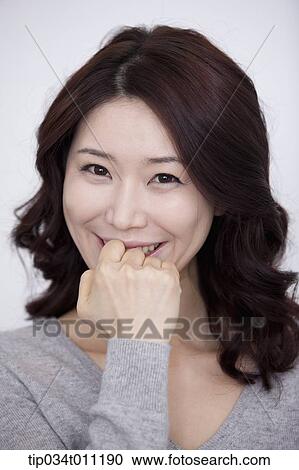 Stock Image - a woman in grey plain shirt smiling. Fotosearch