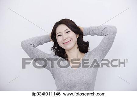 Stock Photograph - a woman in grey plain shirt smiling. Fotosearch
