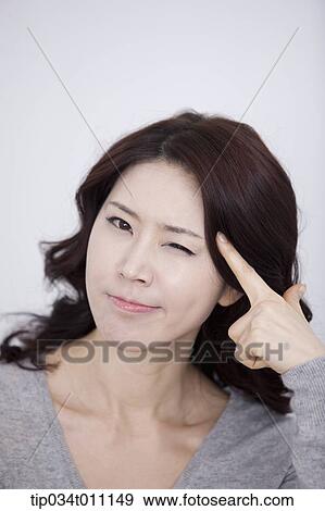 Stock Photo - a woman in grey plain shirt thinking. Fotosearch