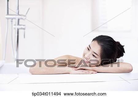 Picture - a woman in leaning on a Jacuzzi. Fotosearch